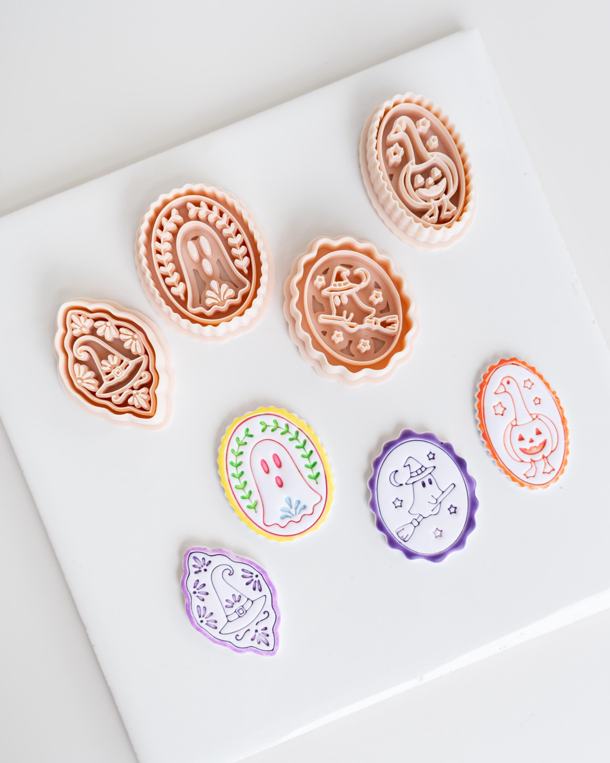 a collection of seven round cookie cutters with various designs, including a ghost, a pumpkin, and other Halloween-themed decorations.