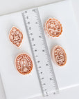 four decorative cookie cutters of various shapes and sizes, placed on a white surface next to a ruler for size comparison.