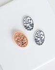 Halloween oval clay cutter with crescent moon and cat design shown beside two matching black and white polymer clay earring pieces.