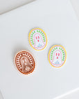 three circular or oval-shaped cookies with different designs and colors, placed on a white surface.