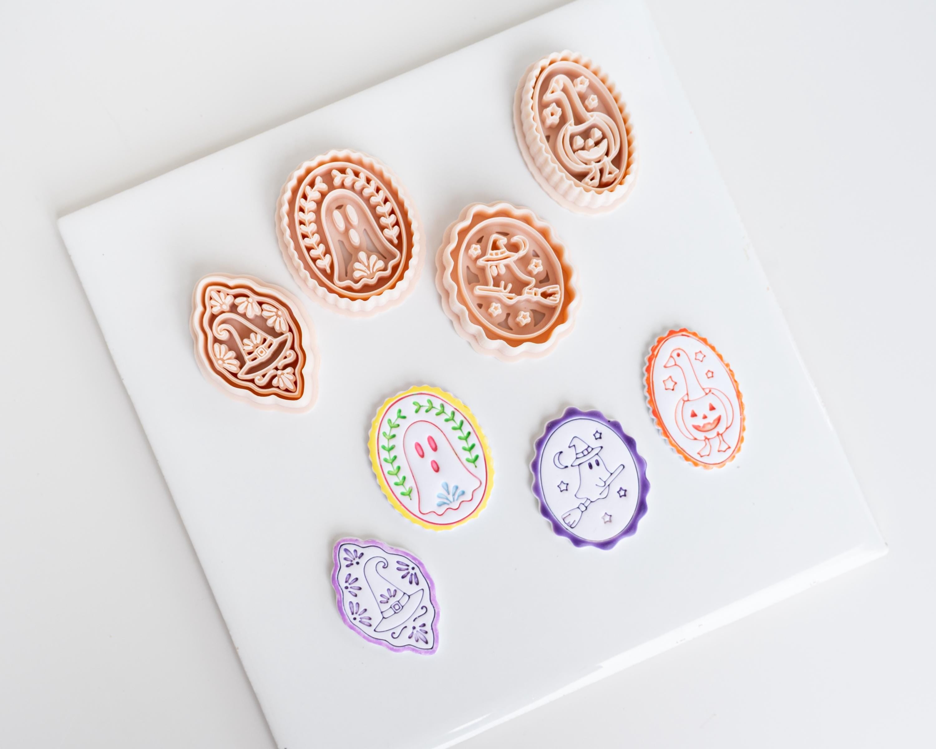 a collection of seven uniquely shaped cookie cutters, each with a distinct design, arranged on a white surface.