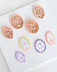 a collection of seven uniquely shaped cookie cutters, each with a distinct design, arranged on a white surface.
