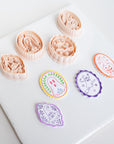 a collection of seven cookie cutters with various shapes and designs, including a ghost, a pumpkin, and other festive or decorative elements.