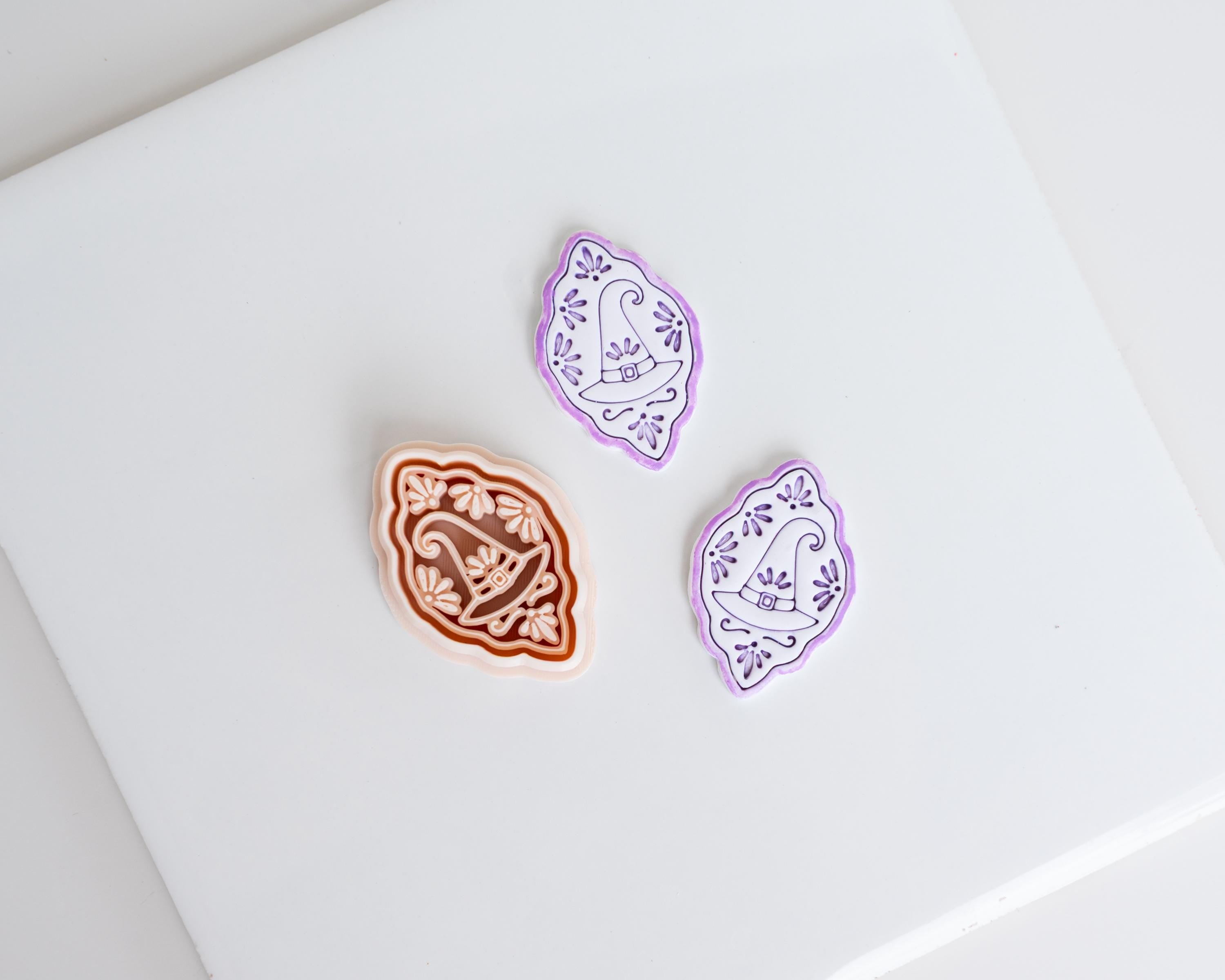 three decorative objects, including a brown and white patterned object, a purple and white patterned object, and a white object with a purple and white pattern.
