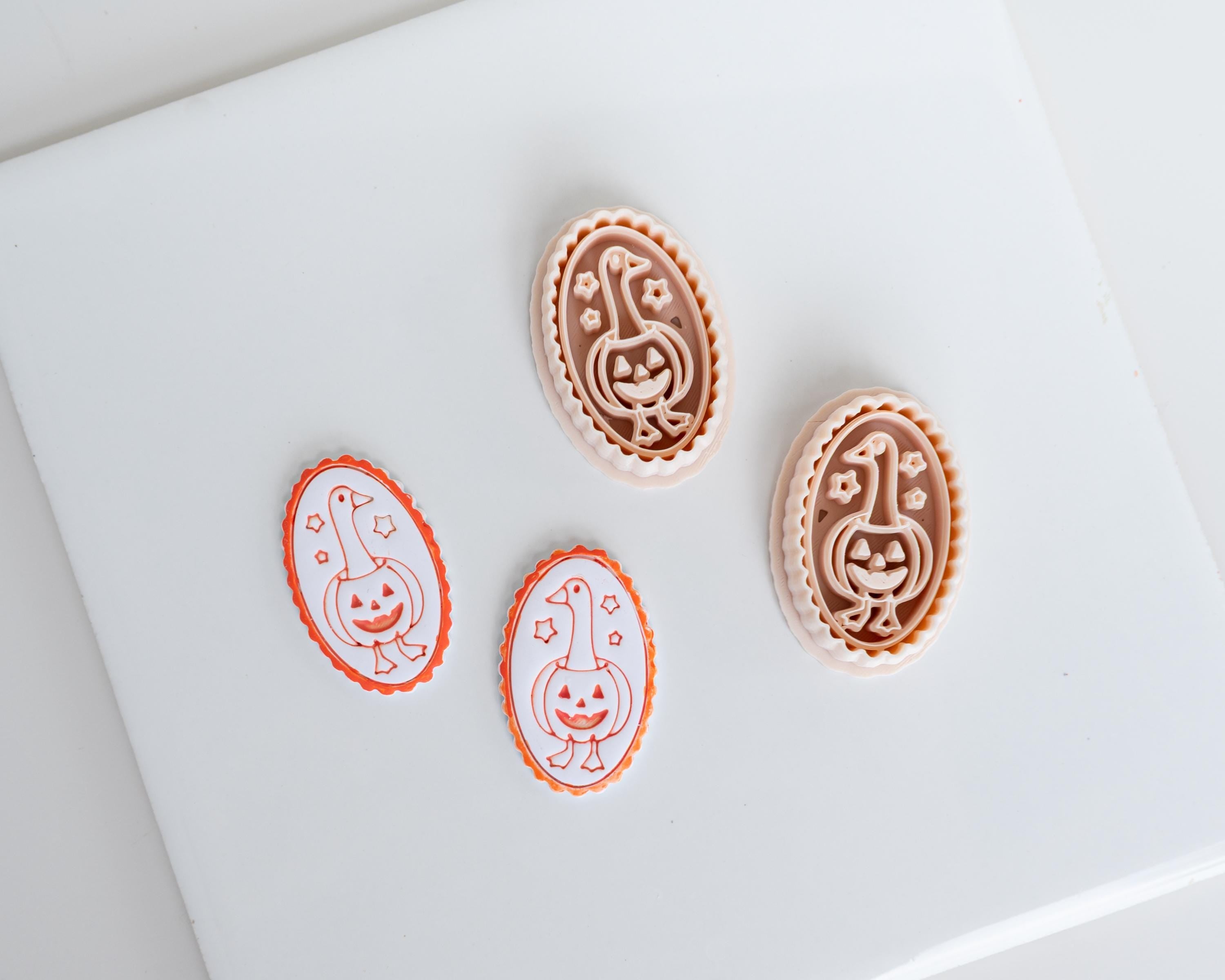 three Halloween-themed cookie cutters, each with a unique design, placed on a white surface.
