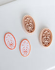 three Halloween-themed cookie cutters, each with a unique design, placed on a white surface.